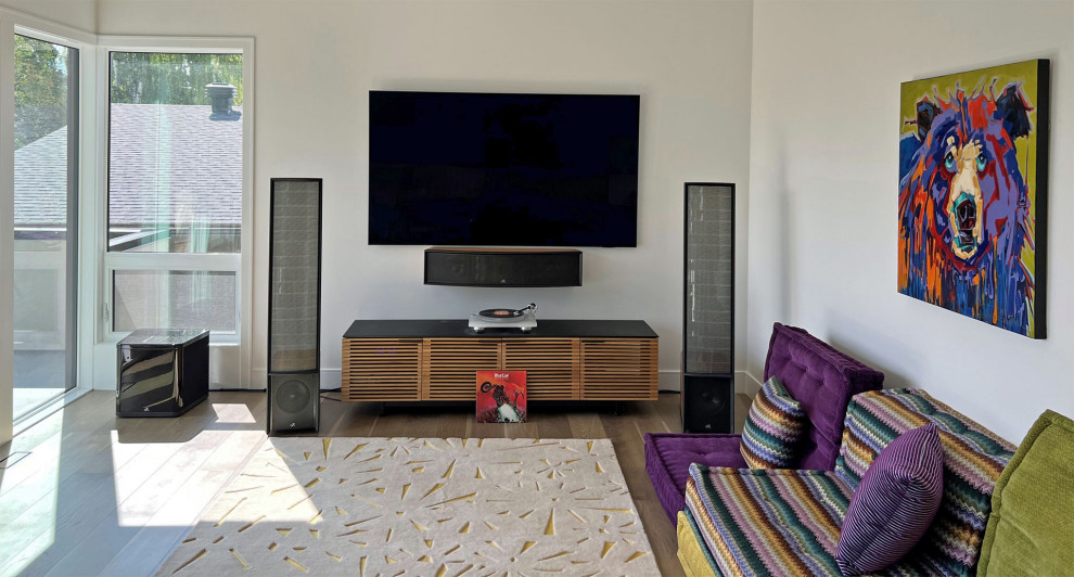 Imagen de sala de estar con rincón musical abierta minimalista grande con paredes beige, suelo de madera en tonos medios, televisor colgado en la pared y suelo marrón