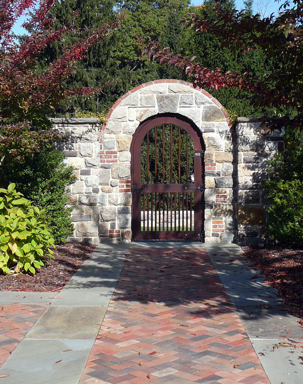 Photo of an expansive traditional courtyard partial sun driveway for spring in New York with a garden path and brick pavers.