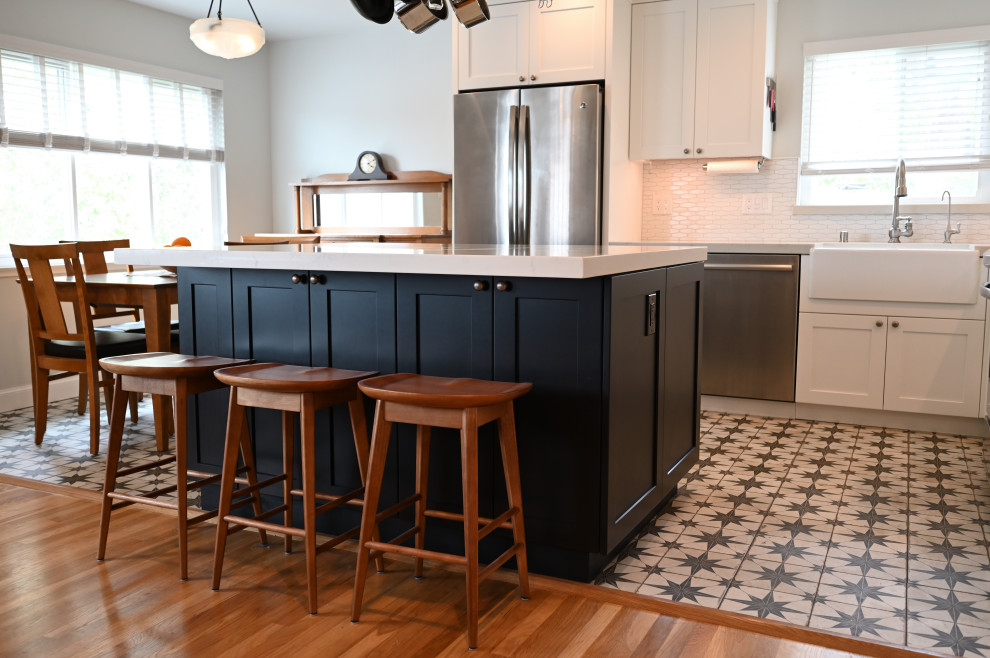 Eat-in kitchen - mid-sized transitional l-shaped porcelain tile and brown floor eat-in kitchen idea in San Francisco with an undermount sink, shaker cabinets, black cabinets, quartz countertops, white backsplash, ceramic backsplash, stainless steel appliances, an island and white countertops