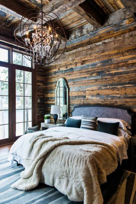 Großes Uriges Hauptschlafzimmer mit weißer Wandfarbe, hellem Holzboden, Kamin, Kaminumrandung aus Stein, grauem Boden, gewölbter Decke und vertäfelten Wänden in Orange County