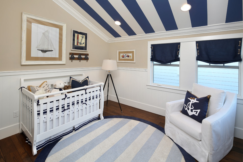 This is an example of a beach style gender-neutral nursery in San Francisco with beige walls and dark hardwood floors.