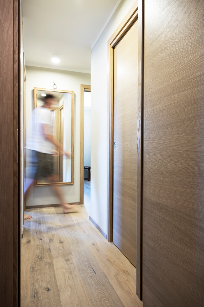 This is an example of a hallway in Other with light hardwood floors.