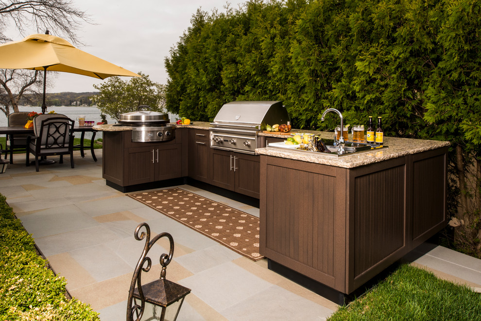 This is an example of a large traditional patio in Chicago with an outdoor kitchen and tile.