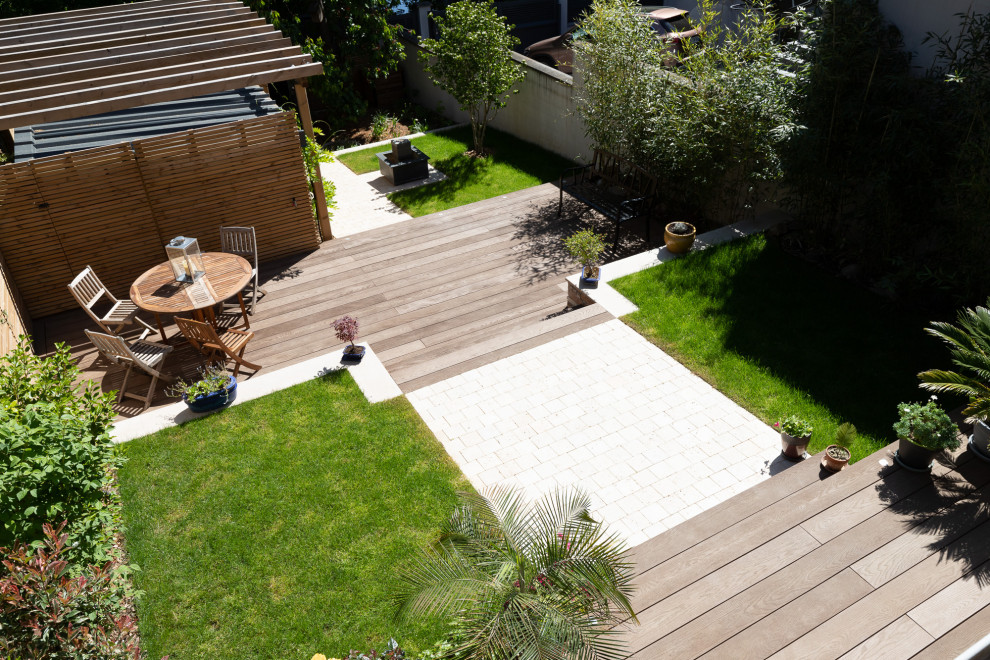 Design ideas for a mid-sized transitional front yard full sun garden for summer in Paris with decking.