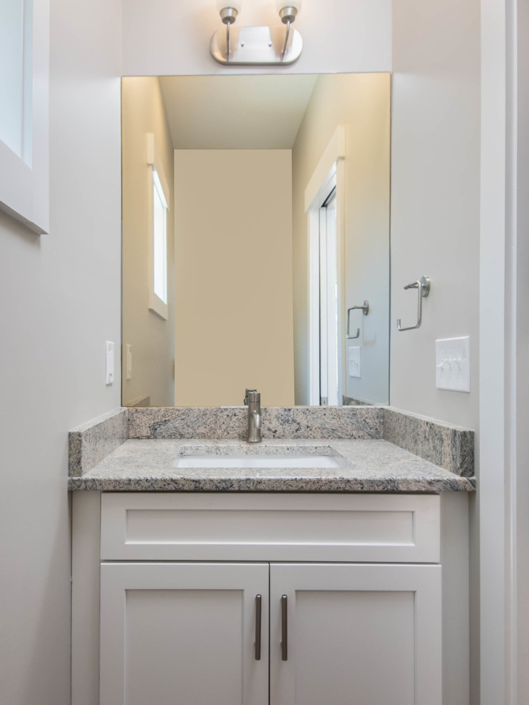 Small transitional powder room in Other with shaker cabinets, white cabinets, a two-piece toilet, grey walls, ceramic floors, an undermount sink, granite benchtops, beige floor and grey benchtops.