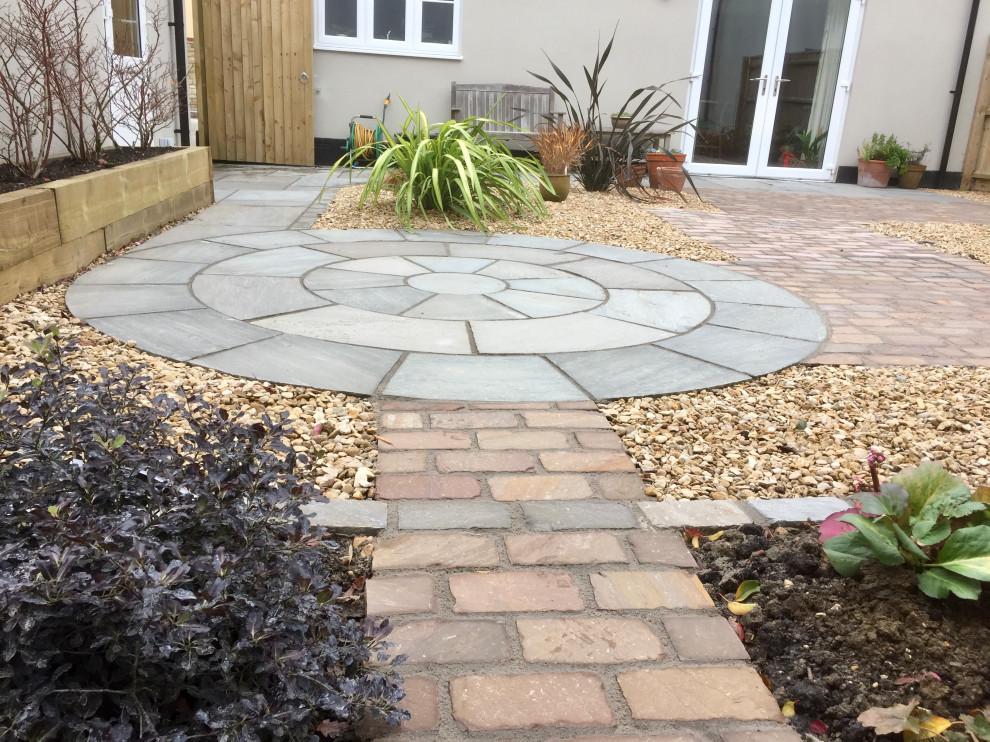 Small transitional backyard partial sun formal garden in Wiltshire with with path, natural stone pavers and a stone fence for summer.