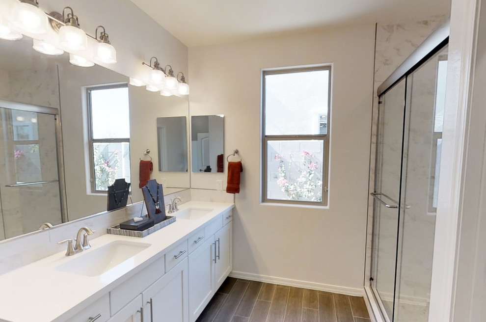 Corner shower - mid-sized transitional master corner shower idea in Phoenix with shaker cabinets, white cabinets, white walls and a drop-in sink