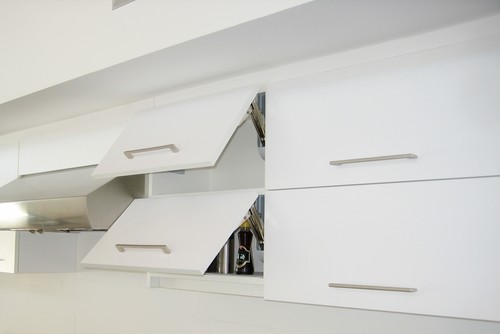 Modern white kitchen cabinet with soft-close lift-up hinges, upper doors partially open