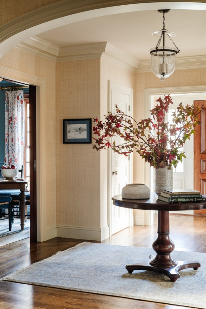 Klassischer Eingang mit beiger Wandfarbe, braunem Holzboden, Einzeltür, hellbrauner Holzhaustür, braunem Boden und Tapetenwänden in Boston