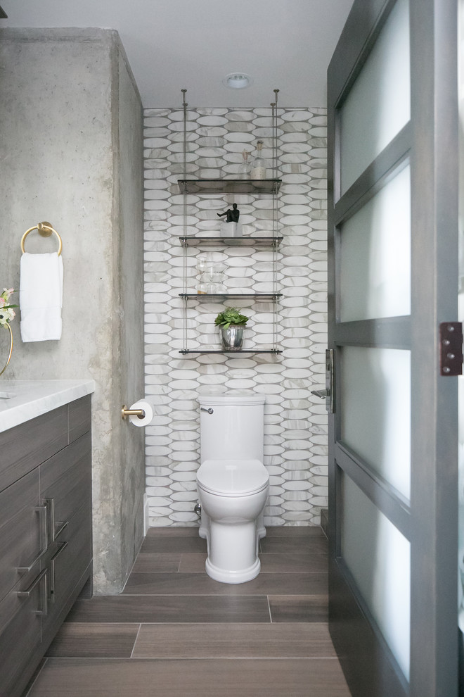 Mid-sized industrial 3/4 wet room bathroom in Denver with flat-panel cabinets, grey cabinets, a two-piece toilet, gray tile, marble, grey walls, porcelain floors, an undermount sink, quartzite benchtops, grey floor and a hinged shower door.