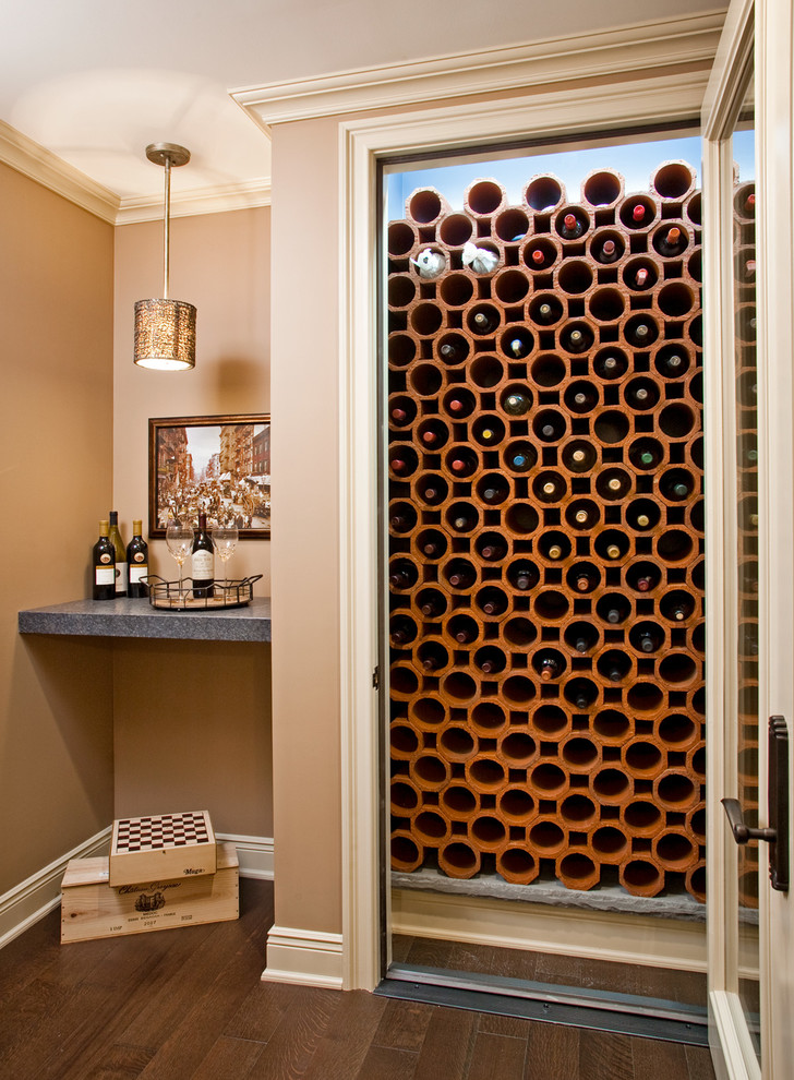 This is an example of a traditional wine cellar in Philadelphia with dark hardwood floors and storage racks.