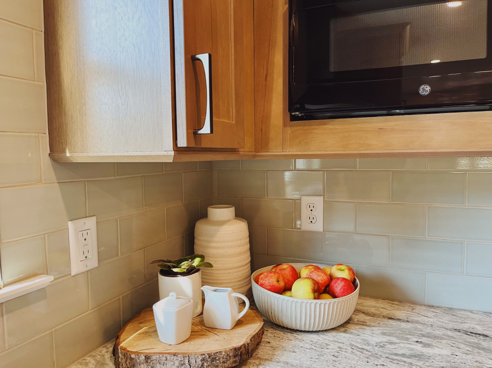 Eat-in kitchen - mid-sized transitional l-shaped vinyl floor and beige floor eat-in kitchen idea with a farmhouse sink, shaker cabinets, medium tone wood cabinets, quartzite countertops, green backsplash, ceramic backsplash, stainless steel appliances, no island and beige countertops