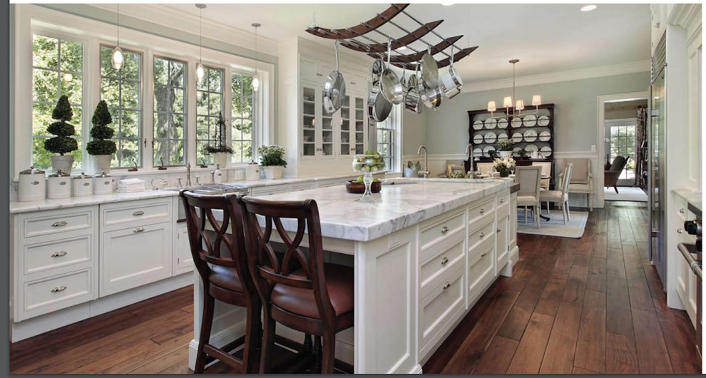 Huge transitional galley medium tone wood floor eat-in kitchen photo in Atlanta with an island, an undermount sink, recessed-panel cabinets, white cabinets, marble countertops and stainless steel appliances