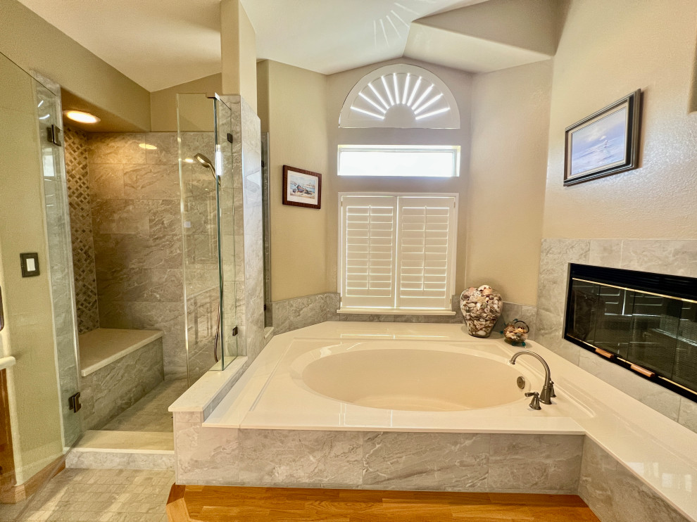 Exemple d'une grande salle de bain principale chic avec une baignoire encastrée, une douche d'angle, un carrelage gris, des carreaux de porcelaine, un mur beige, un sol en carrelage de porcelaine, un sol gris, une cabine de douche à porte battante et buanderie.