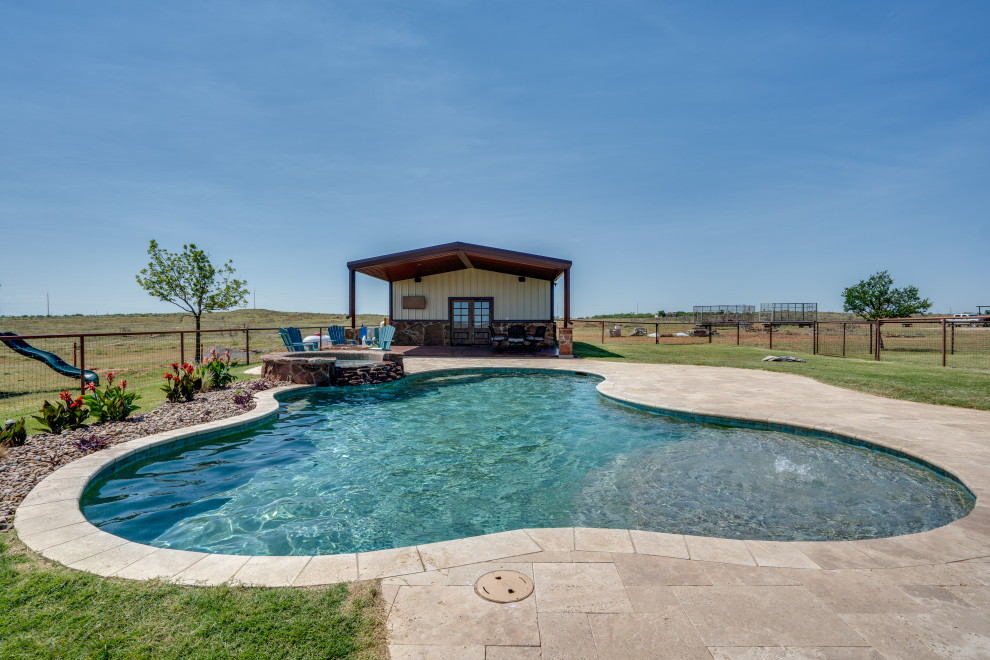 Example of a mid-sized mountain style backyard stone and custom-shaped hot tub design in Austin
