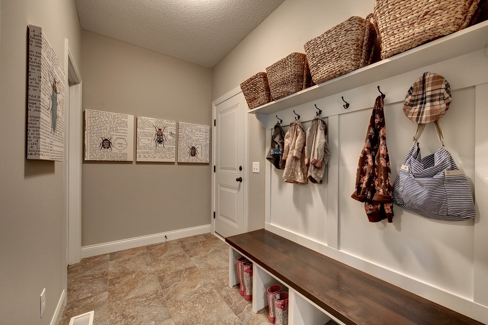 This is an example of a large traditional mudroom in Minneapolis with grey walls, ceramic floors, a single front door and a white front door.
