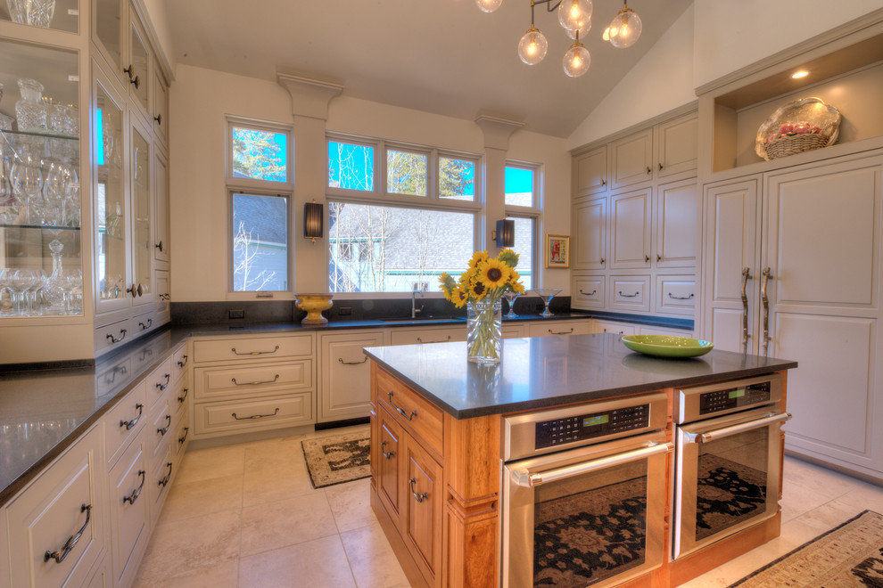 Photo of a mid-sized country u-shaped separate kitchen in Denver with an undermount sink, beaded inset cabinets, light wood cabinets, quartz benchtops, beige splashback, stone slab splashback, panelled appliances, travertine floors and with island.