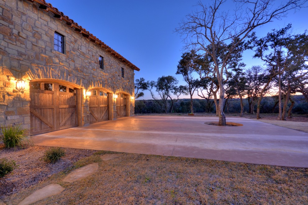 Inspiration for a large rustic attached three-car garage remodel in Austin