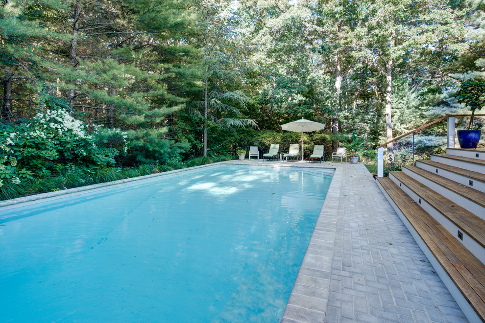 Example of a large transitional backyard stamped concrete and rectangular pool design