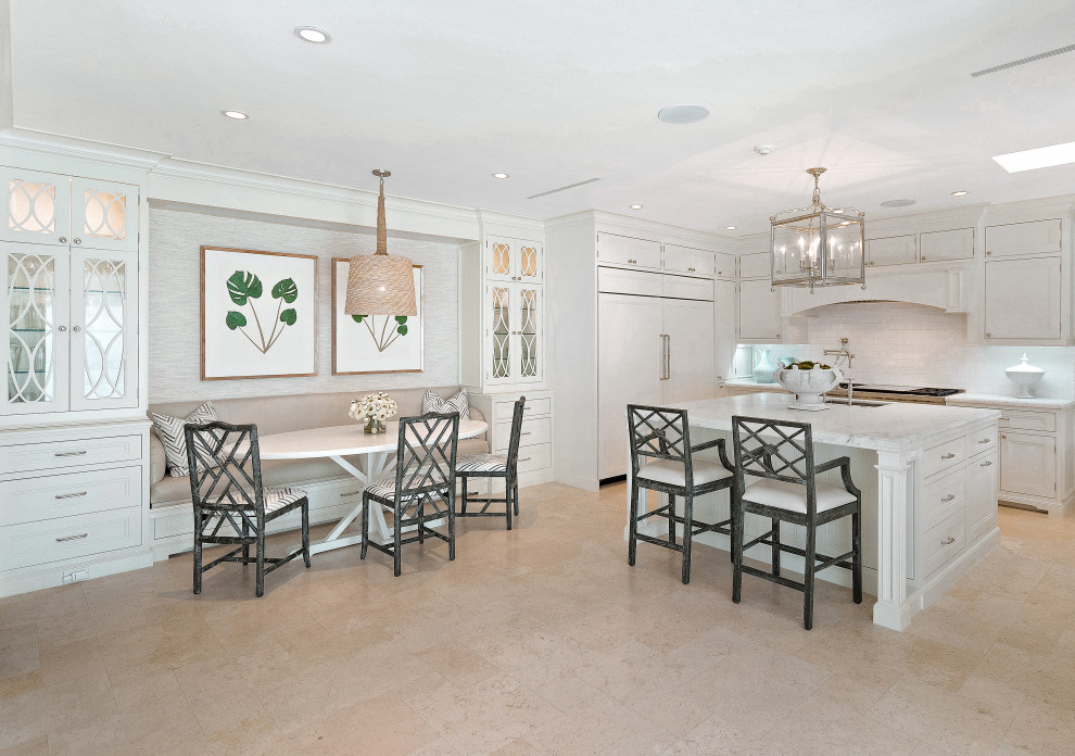Photo of an expansive nautical l-shaped kitchen/diner in Miami with a submerged sink, recessed-panel cabinets, white cabinets, white splashback, stainless steel appliances, an island, beige floors and white worktops.