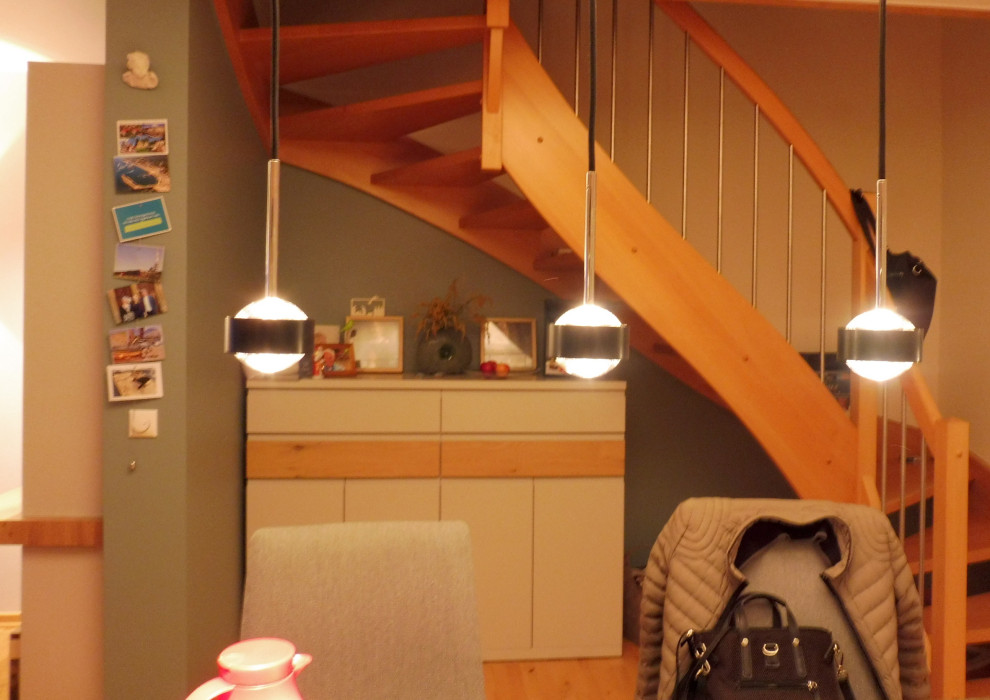 На фото: изогнутая лестница среднего размера в классическом стиле с деревянными ступенями, подступенками из сланца, деревянными перилами и обоями на стенах с