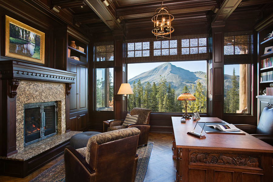 Large country study room in Other with brown walls, medium hardwood floors, a standard fireplace, a tile fireplace surround, a freestanding desk and brown floor.