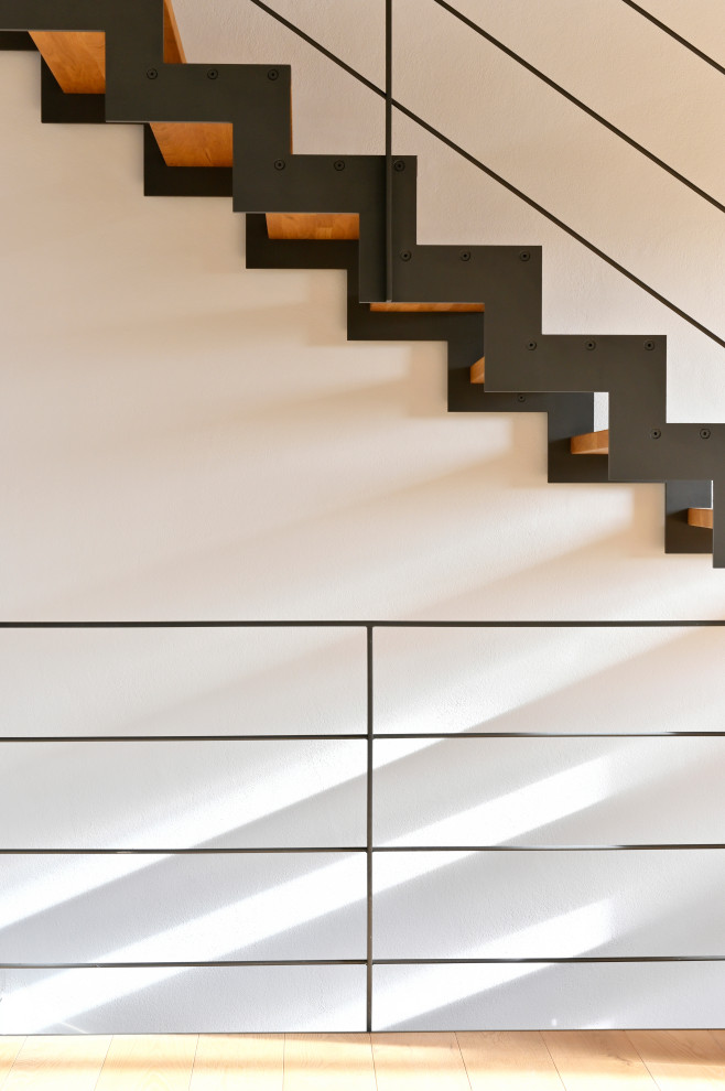 Свежая идея для дизайна: изогнутая лестница среднего размера в стиле лофт с деревянными ступенями и металлическими перилами без подступенок - отличное фото интерьера