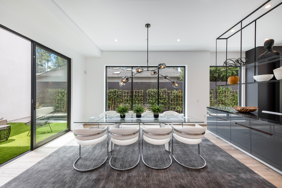 Contemporary dining room in Los Angeles with white walls, light hardwood floors and beige floor.