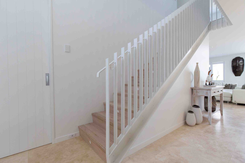 Example of a mid-sized minimalist wooden straight metal railing staircase design in Auckland with wooden risers