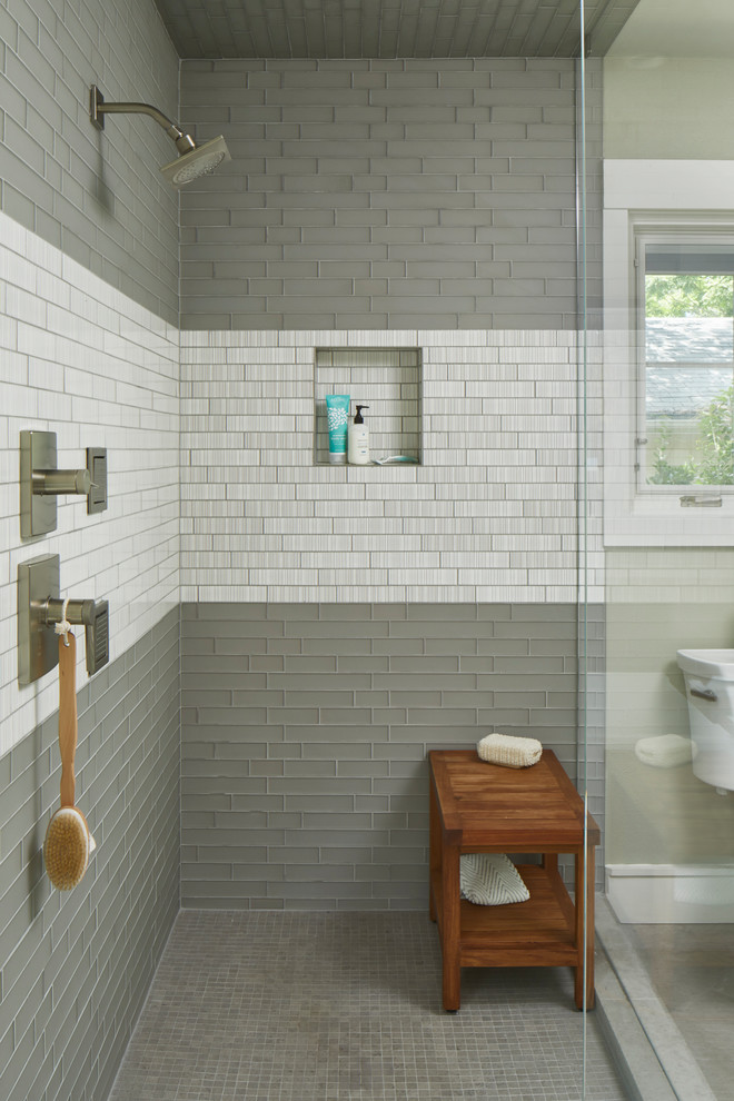 This is an example of a small country master bathroom in Austin with flat-panel cabinets, medium wood cabinets, a freestanding tub, an open shower, a one-piece toilet, gray tile, glass tile, grey walls, limestone floors, a drop-in sink, marble benchtops, grey floor, a hinged shower door and white benchtops.