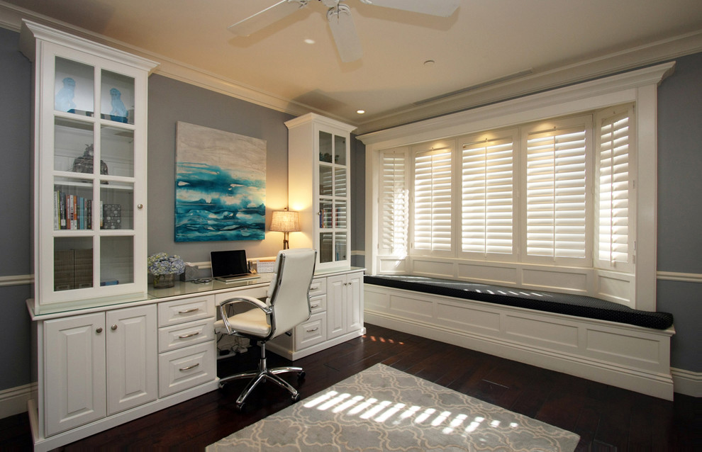 Example of a mid-sized minimalist freestanding desk dark wood floor study room design in Orange County with gray walls