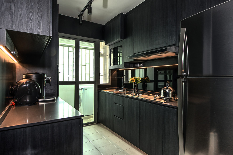 Inspiration for a small contemporary galley separate kitchen in Singapore with an undermount sink, flat-panel cabinets, black cabinets, black splashback, glass sheet splashback, black appliances, ceramic floors and no island.