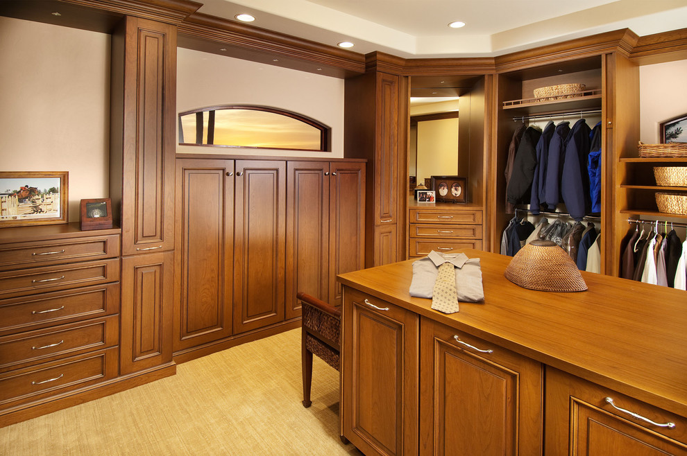 Inspiration for a large transitional men's walk-in wardrobe in Phoenix with raised-panel cabinets, medium wood cabinets and carpet.