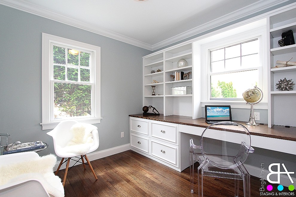 This is an example of a small modern home office in New York with grey walls, dark hardwood floors and a built-in desk.