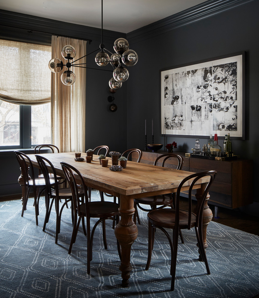 Inspiration for a transitional dining room in Chicago with black walls.