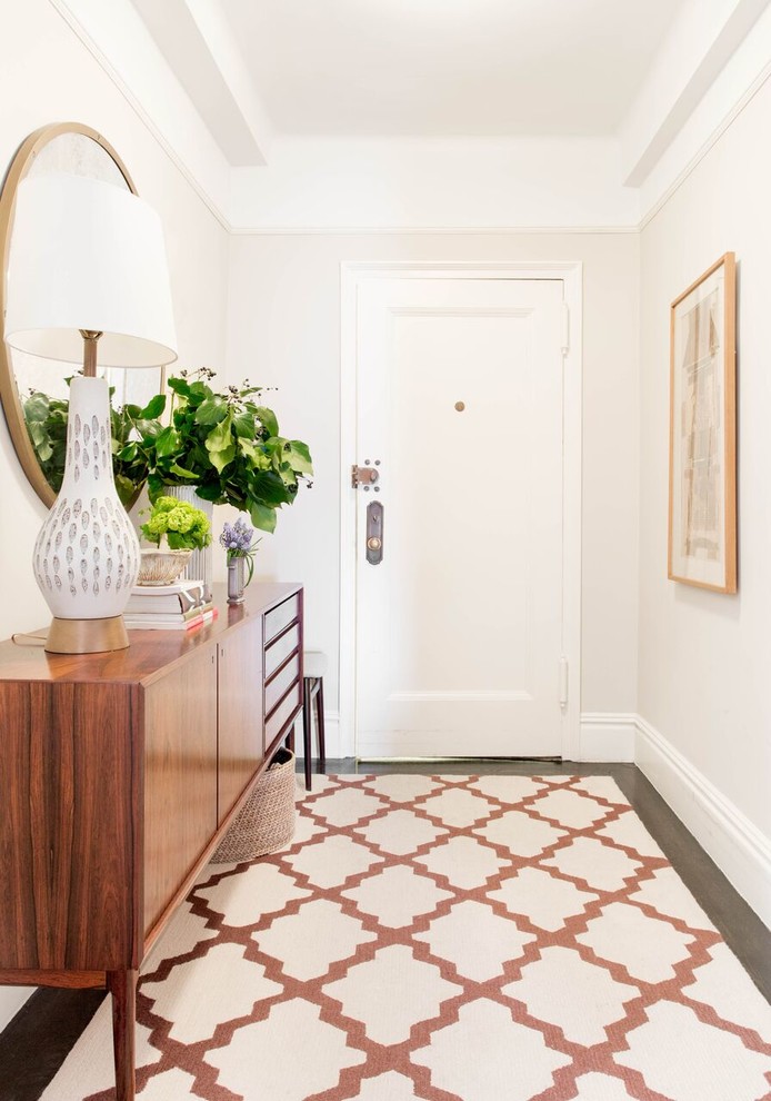 Inspiration for a mid-sized transitional foyer in New York with white walls, dark hardwood floors, a single front door, a white front door and brown floor.
