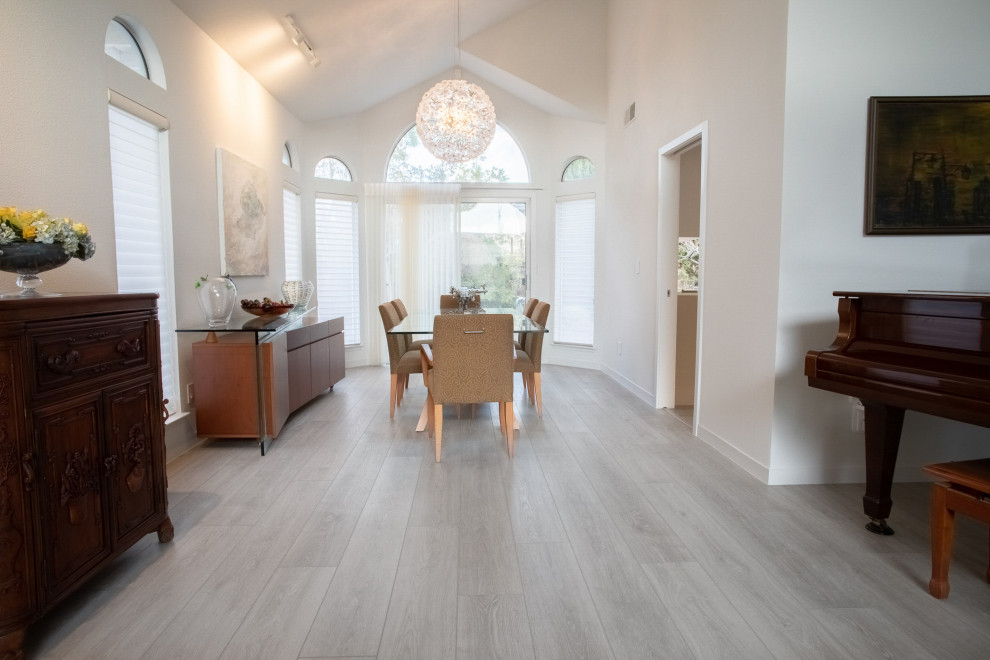Immagine di una grande sala da pranzo aperta verso il soggiorno chic con pareti bianche, pavimento in vinile, pavimento grigio e soffitto a volta