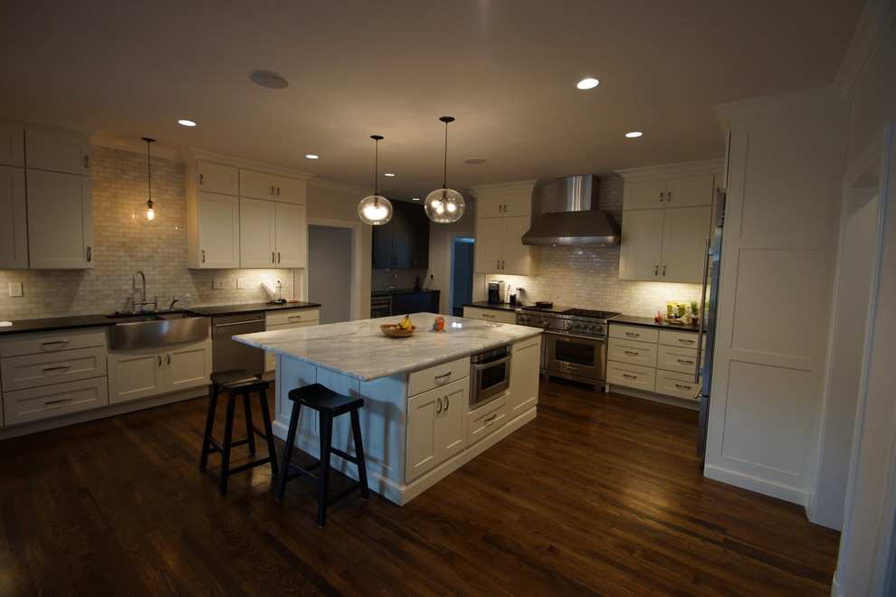 Open concept kitchen - large transitional medium tone wood floor open concept kitchen idea in Nashville with a farmhouse sink, shaker cabinets, white cabinets, gray backsplash, stainless steel appliances and an island