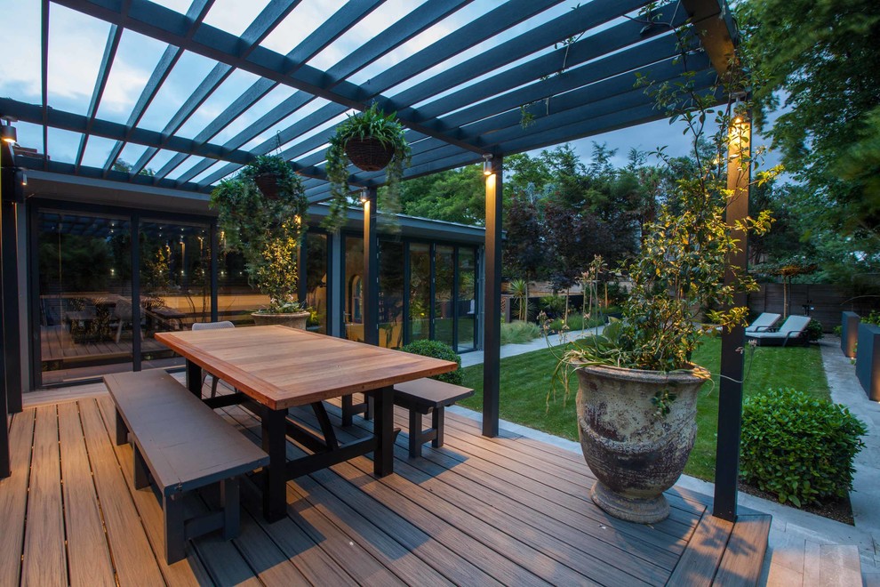Design ideas for a mid-sized contemporary backyard patio in Hampshire with decking and a pergola.