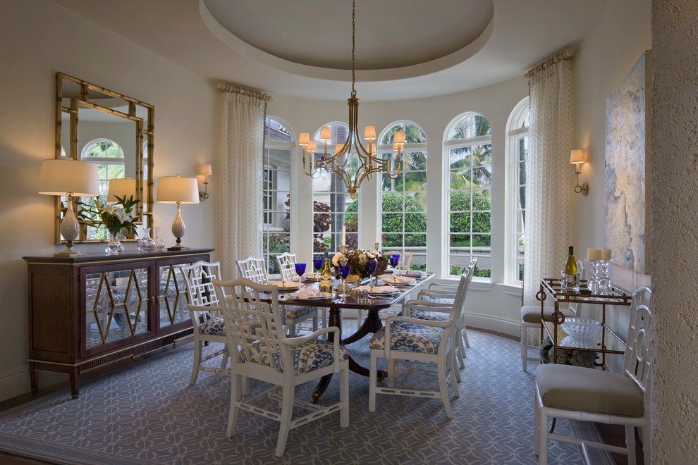 This is an example of a mid-sized mediterranean separate dining room in Miami with white walls, carpet and blue floor.
