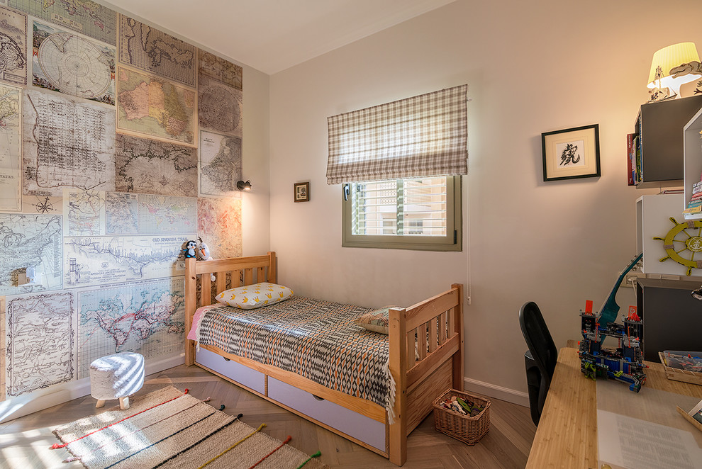 Mid-sized scandinavian gender-neutral kids' room in Other with beige walls and light hardwood floors for kids 4-10 years old.