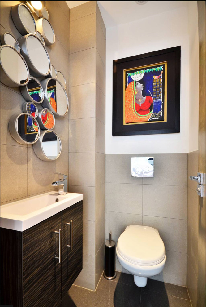 Small contemporary powder room in London with flat-panel cabinets, black cabinets, a one-piece toilet, grey walls, a wall-mount sink and black floor.
