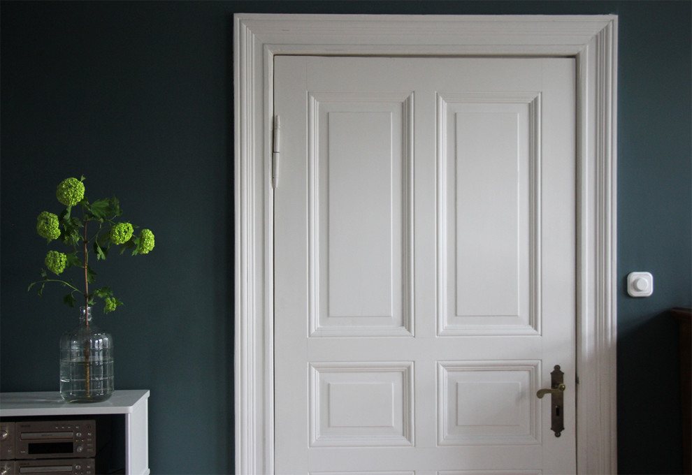 Eklektisches Wohnzimmer mit blauer Wandfarbe und hellem Holzboden in Berlin