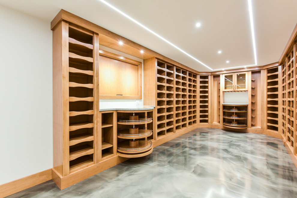 Large traditional wine cellar in Chicago with storage racks and grey floors.