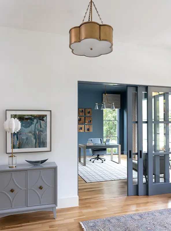 Inspiration for an expansive transitional entryway in Dallas with white walls, light hardwood floors, a sliding front door and a blue front door.