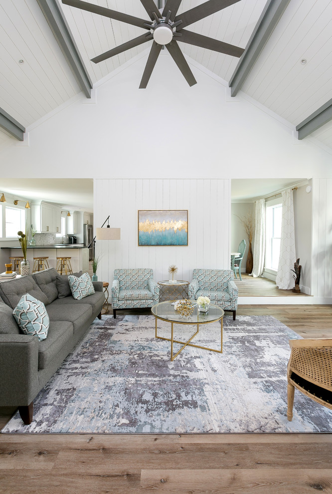 This is an example of a transitional open concept living room in Charleston with white walls and brown floor.