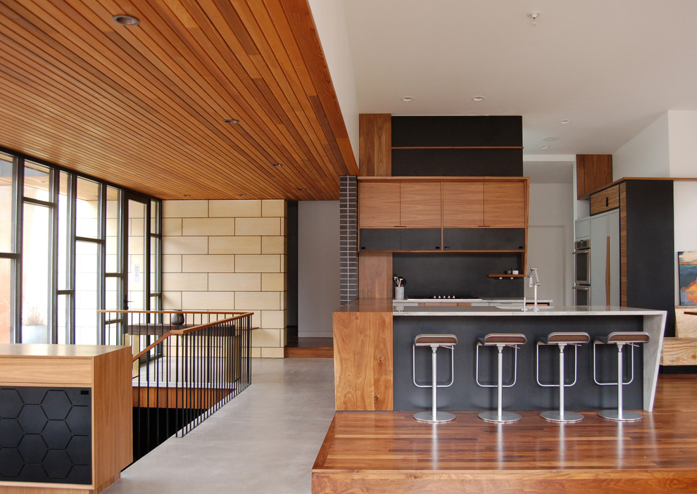 This is an example of a midcentury kitchen in Minneapolis with open cabinets, dark wood cabinets, marble benchtops, black splashback, panelled appliances and dark hardwood floors.