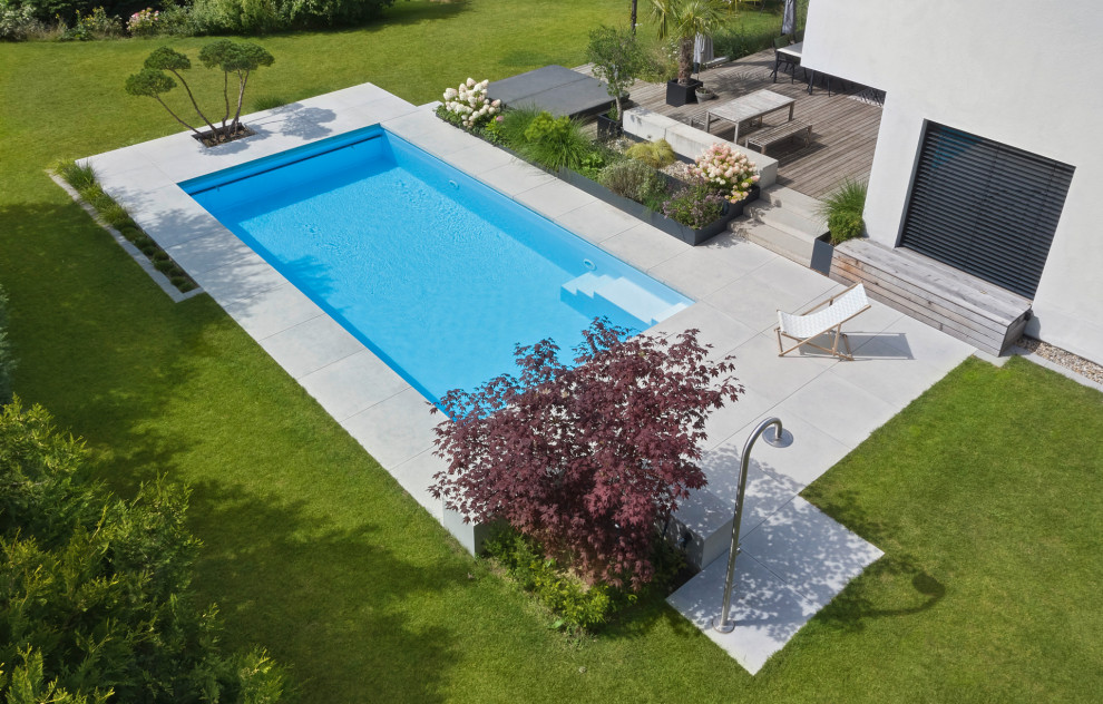 Diseño de piscina minimalista rectangular en patio lateral con paisajismo de piscina