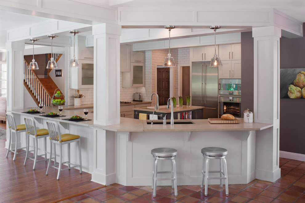 Example of a large transitional l-shaped medium tone wood floor and brown floor eat-in kitchen design in Austin with soapstone countertops, a drop-in sink, shaker cabinets, white cabinets, white backsplash, subway tile backsplash, stainless steel appliances and a peninsula