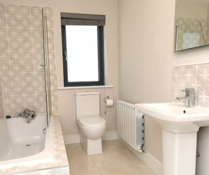 Example of a mid-sized trendy kids' beige tile and ceramic tile porcelain tile, beige floor and single-sink bathroom design in Cork with a wall-mount toilet, beige walls, a drop-in sink and a built-in vanity
